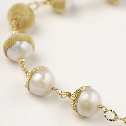 Adjustable bracelet with baroque pearls wrapped in delicate gold mesh netting connected by textured chain links