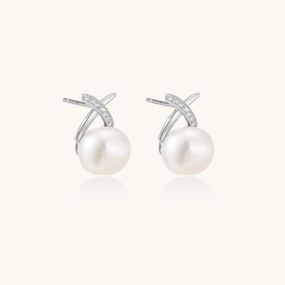 Rhodium-plated silver stud earrings with sparkling X design above lustrous round freshwater pearls on white background.