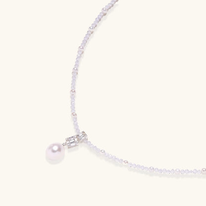 Dainty necklace with lavender crystal beads, freshwater pearls, geometric pendant, and large pearl drop on white background.