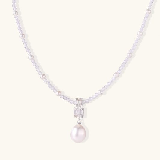 Dainty necklace with lavender crystal beads, freshwater pearls, geometric pendant, and large pearl drop on white background.