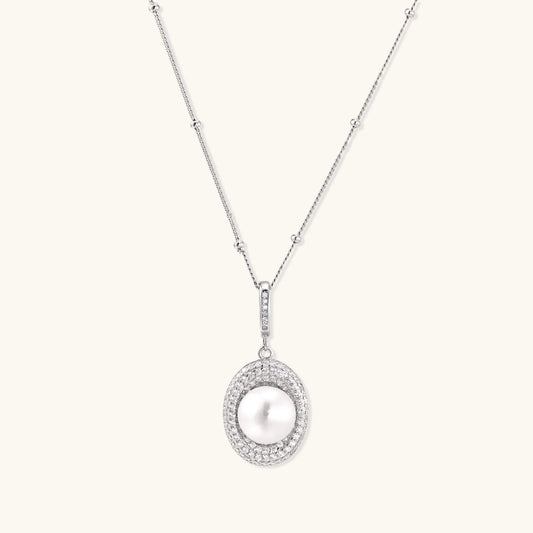 Oval sterling silver pendant with crystal halo surrounding a white freshwater pearl on delicate chain