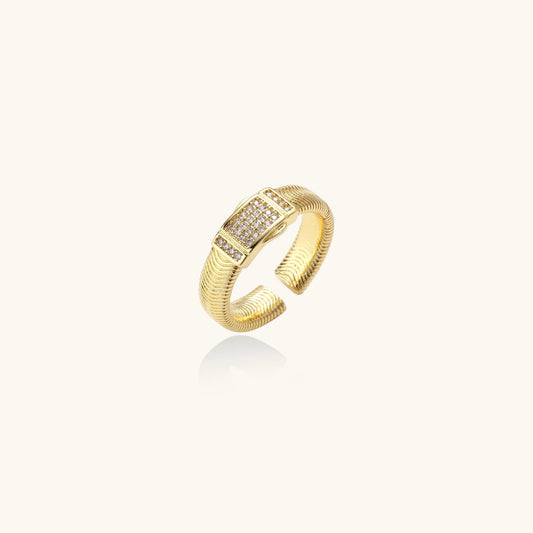 Gold-plated adjustable ring with ribbed band and rectangular pavé cubic zirconia panel on white background.