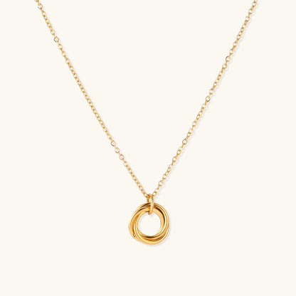 Delicate gold-plated necklace with three interlocking circle rings forming a minimalist knot pendant on cream background